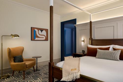 a bedroom with a bed and a chair at Dearborn Inn, Autograph Collection in Dearborn