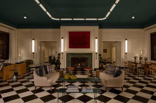 a living room with a fireplace and chairs and a table at Dearborn Inn, Autograph Collection in Dearborn