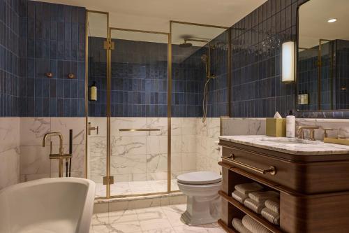 a bathroom with a tub and a toilet and a shower at Dearborn Inn, Autograph Collection in Dearborn
