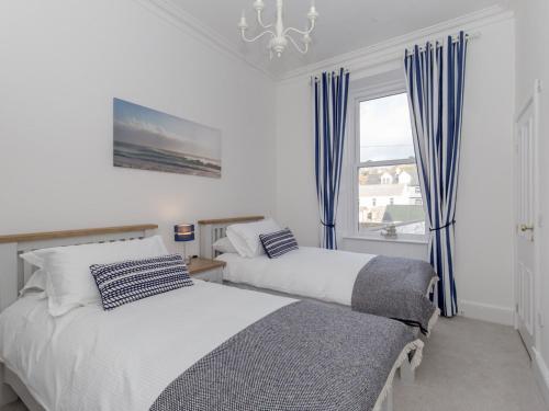 two beds in a room with a window at Holiday Home Portpatrick House by Interhome in Portpatrick