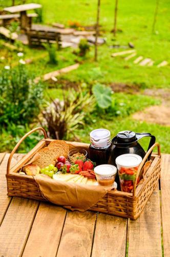 un cesto da picnic con cibo su un tavolo di legno di Sítio Porteira Sete, Cabana no Vale a Urubici
