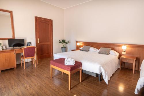 a bedroom with a bed and a desk and a television at Sottoassisi - Guest House in Assisi