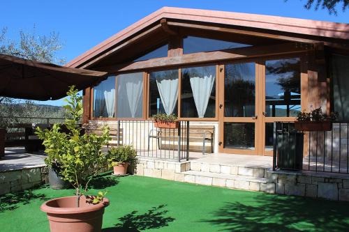 a house with large windows and green grass at Agriturismo Fara del Falco in Vieste