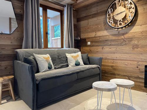 a living room with a couch and a clock on the wall at Club Alpina - Champagny-en-Vanoise in Champagny-en-Vanoise