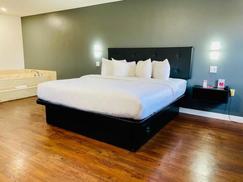 a bedroom with a large bed with white sheets at Econo Lodge Hotel Brossard in Brossard