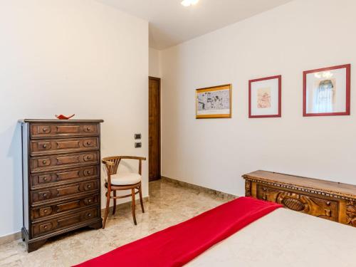 a bedroom with a bed and a dresser and a chair at Apartment Casa Luli by Interhome in Gravedona