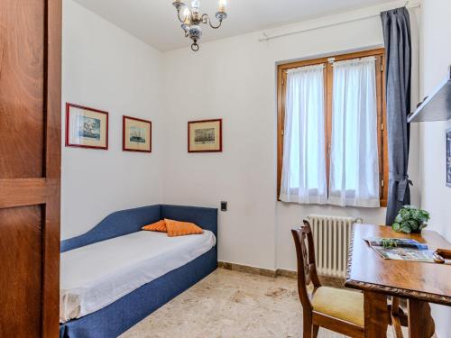 a small bedroom with a bed and a table at Apartment Casa Luli by Interhome in Gravedona