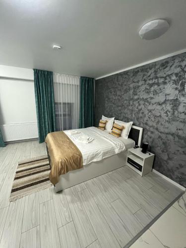 a bedroom with a large bed and a stone wall at Grey Boutique Hotel Palas in Iaşi