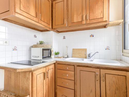 - une cuisine avec des placards en bois et un four micro-ondes dans l'établissement Apartment Le Mirazur by Interhome, à Nice