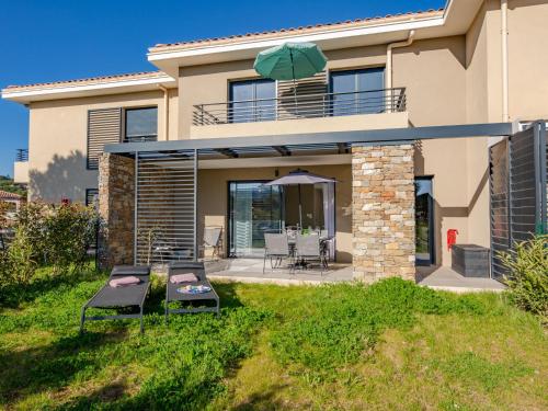 une maison avec une terrasse et un parasol dans l'établissement Holiday Home Le Clos d'Alice-2 by Interhome, à Sainte-Maxime