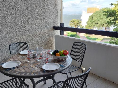 une table avec un bol de fruits sur un balcon dans l'établissement Apartment Dominica-6 by Interhome, au Barcarès