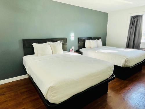 two beds sitting next to each other in a room at Econo Lodge Hotel Brossard in Brossard