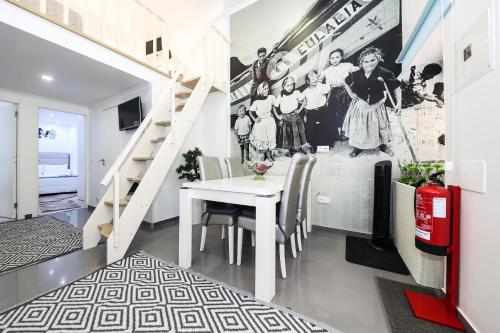 a dining room with a white table and a staircase at Dina Beach House in Nazaré