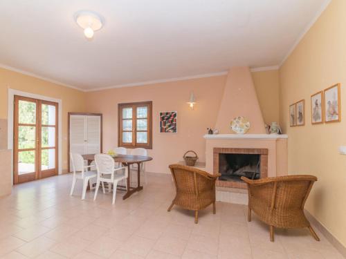 a living room with a fireplace and a table and chairs at Holiday Home Vignola House 2 by Interhome in Aglientu