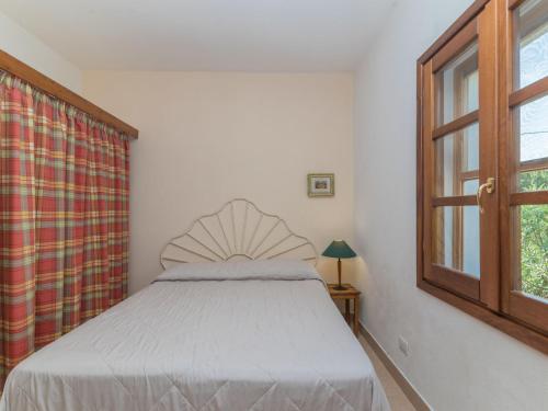 a bedroom with a bed and a window at Holiday Home Vignola House 2 by Interhome in Aglientu
