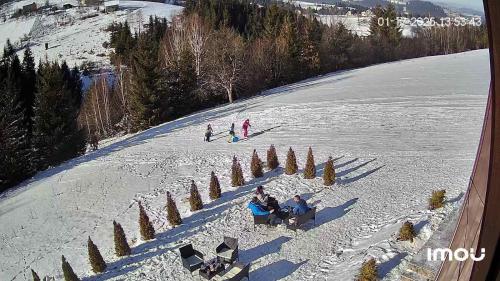 a group of people sitting on a snow covered slope at Zlatar Eyes in Nova Varoš