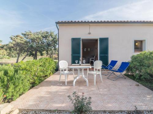 a patio with a table and chairs in front of a house at Holiday Home Vignola House 2 by Interhome in Aglientu