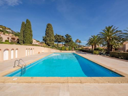 - une piscine dans une villa avec des palmiers dans l'établissement Studio El Cantarello by Interhome, à Sainte-Maxime