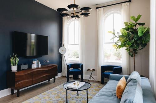 a living room with a blue couch and a tv at The Purple Martin - The Perch in Louisville