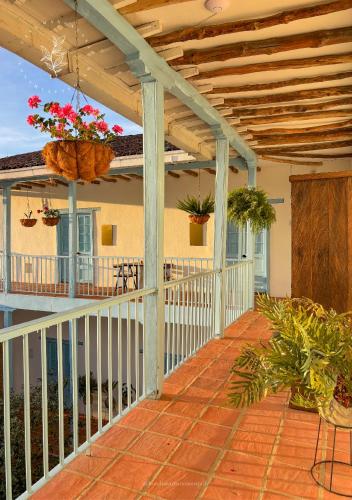 a porch with a white railing and potted plants at Hotel Casa Manoa Sesquile in Sesquilé