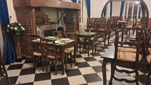 a dining room with tables and chairs and a fireplace at Chalet de la source in Prades