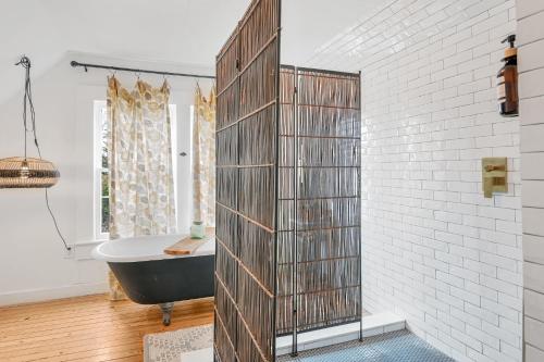 a bathroom with a black tub and a white wall at Asheville Urban Farmhouse Entire Home 4 mi to DT in Asheville