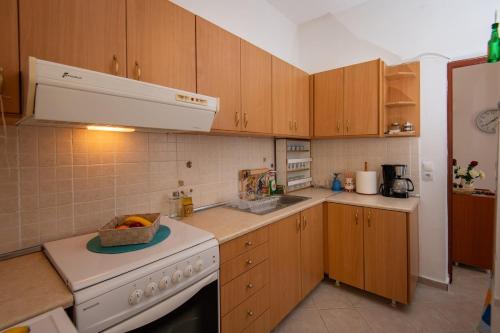 a kitchen with wooden cabinets and a white stove top oven at Aegean Heaven in Samos
