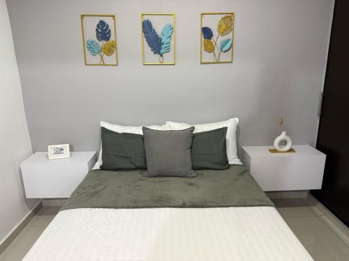 ein Schlafzimmer mit einem Bett mit drei Bildern an der Wand in der Unterkunft Elegance in the heart of wine in Lemos