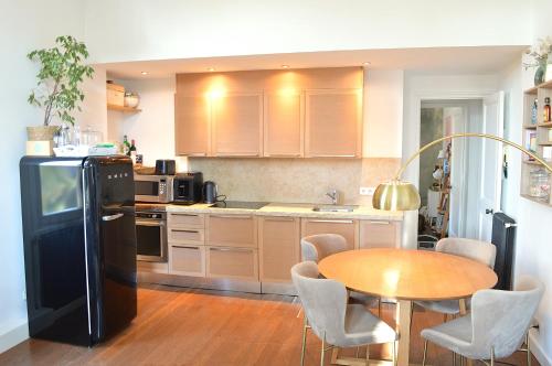 Il comprend une cuisine équipée d'une table et d'un réfrigérateur noir. dans l'établissement Charming Apartment Cannes City Center and Beaches, à Cannes