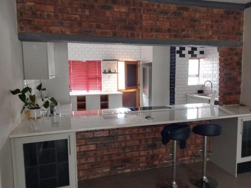 a kitchen with a counter and a brick wall at 04 at Beaumont in King Williamʼs Town