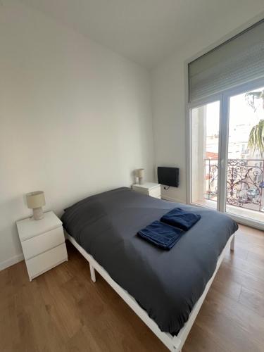 une chambre blanche avec un grand lit et une fenêtre dans l'établissement Appartement proche centre ville, à Perpignan