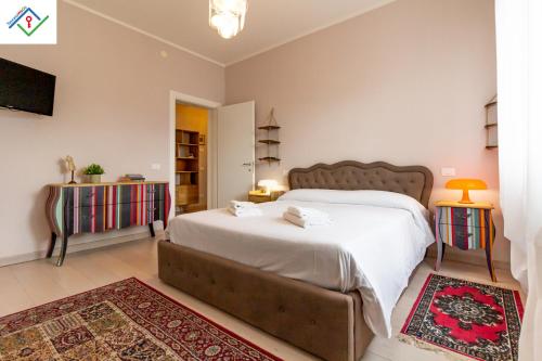 a bedroom with a large bed and two tables at A Casa Di Giò by TuscanyWeGo in Livorno