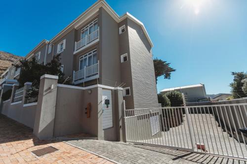 a house with a white fence in front of it at Restore your Soul, Boulders Beach, Seaforth, Simon's Town in Simonʼs Town
