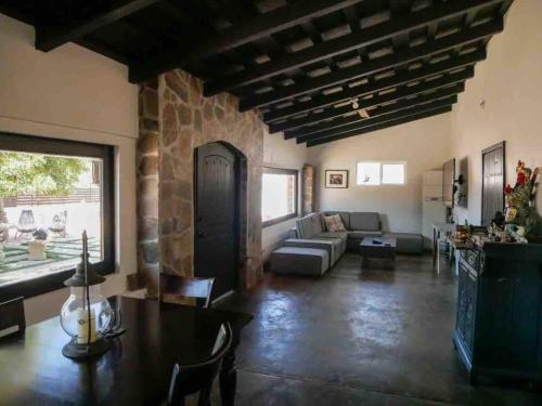a living room with a table and a stone wall at Wine Valley Ranch in Valle de Guadalupe