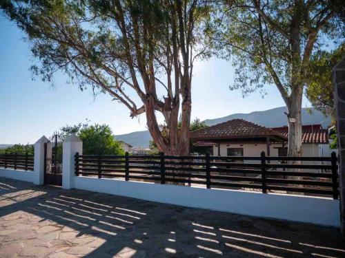 a fence in front of a house with a tree at Wine Valley Ranch in Valle de Guadalupe
