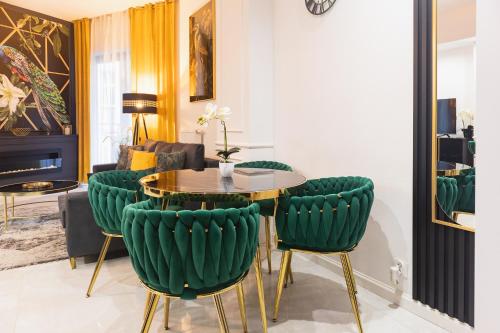 a living room with a table and green chairs at Hanza Tower - Golden Heaven Apartment in Szczecin