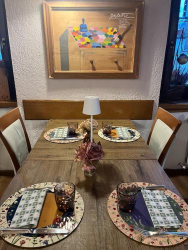 a wooden table with three plates of food on it at Hotel Coeur Du Village in La Thuile