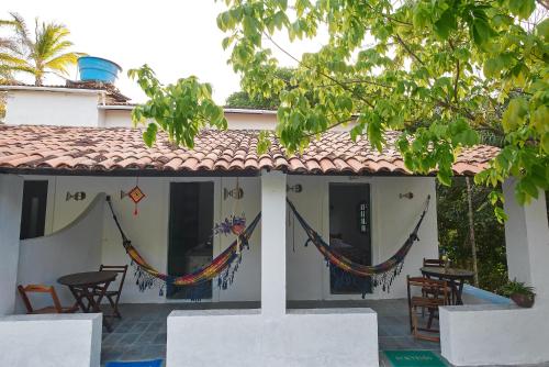 a house with hammocks on the side of it at Despertamar- Hospedagem em Calhetas in Cabo de Santo Agostinho