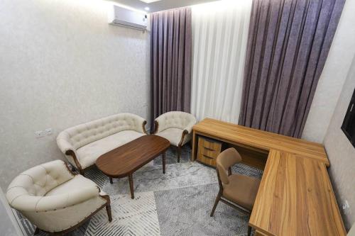 een kamer met twee stoelen, een tafel en een bank bij Florence Hotel in Jizzax