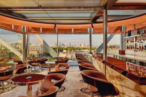 un bar con sillas y mesas y vistas a la ciudad en The Emory, Maybourne, en Londres