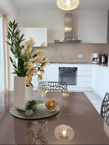 a kitchen with a table with a glass of wine and flowers at Ca' Campitol in Torri del Benaco