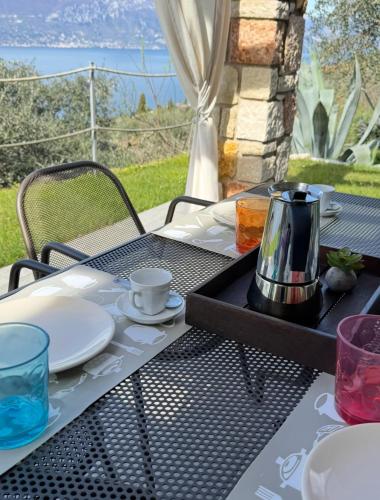 a table with a tea kettle and plates on it at Ca' Campitol in Torri del Benaco