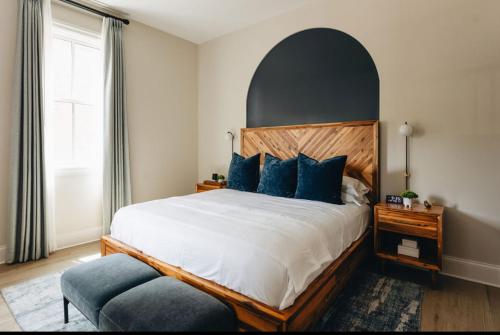 a bedroom with a large bed with blue pillows at The Purple Martin - The Odd Bird in Louisville