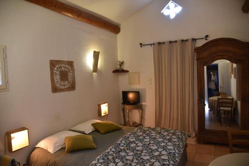 une chambre avec un lit et un grand miroir dans l'établissement Les Mazets de Pascale, à Saint-Rémy-de-Provence