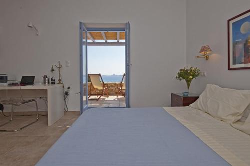 1 dormitorio con cama y escritorio con vistas en Niovi Antiparos Luxury Villas, en Soros