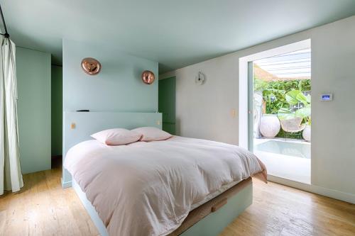 une chambre avec un lit et une grande fenêtre dans l'établissement La Baraka, à Paris