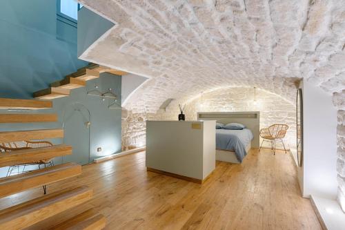 une chambre avec un lit et un mur en pierre dans l'établissement La Baraka, à Paris