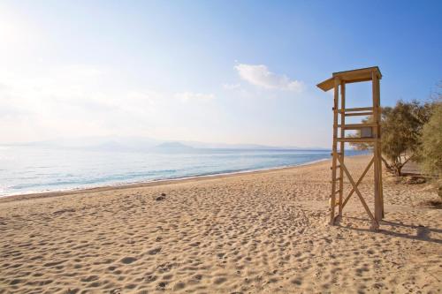 a wooden lifeguard chair on a sandy beach at Birbas Hotel in Agia Anna Naxos