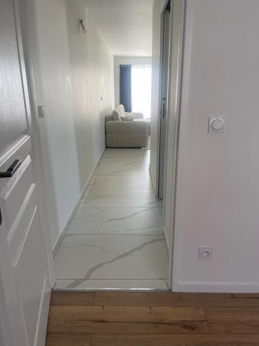 a hallway leading to a living room with a couch at Appartement Moderne in Saint-Cergues