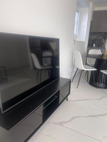 a living room with a flat screen tv at Appartement Moderne in Saint-Cergues